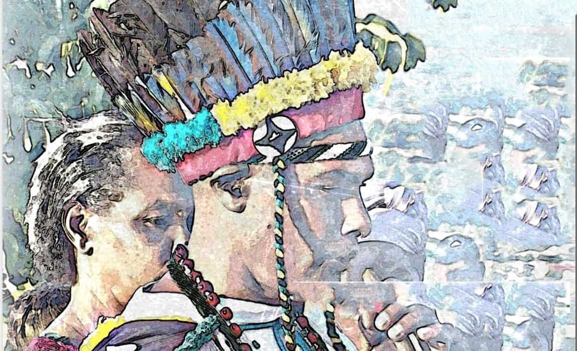 A person wearing a colourful feathered headdress and traditional attire stands in profile, with another person visible beside them in the background.